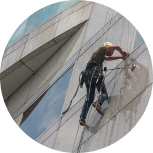 Commercial window cleaner on high-rise using VeriClock for GPS time tracking and job verification.